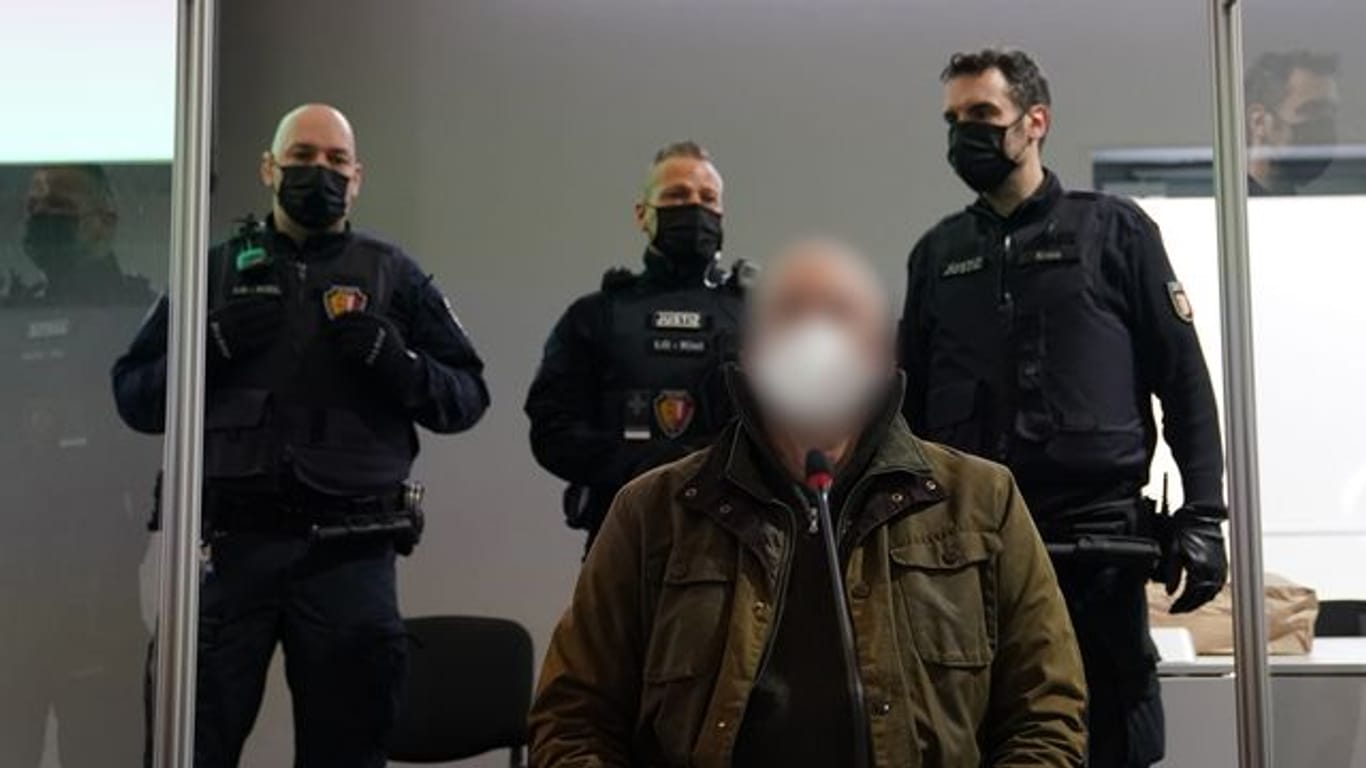 Der Angeklagte (vorne) zu Beginn des Prozesses wegen eines Dreifachmordes im Landgericht Kiel.