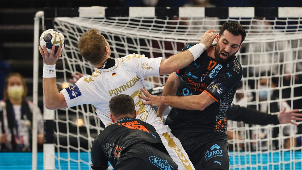 Arthur Lenne (l) und Benjamin Bataille von Montpellier HB verteidigen gegen Kiels Steffen Weinhold (M).