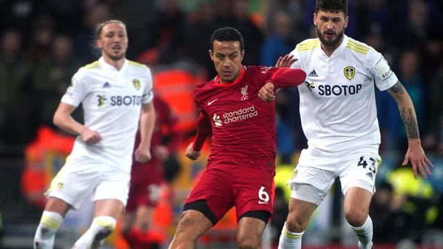 Thiago Alcantara (M) vom FC Liverpool kommt vor Sam Greenwood (r) von Leeds United an den Ball.