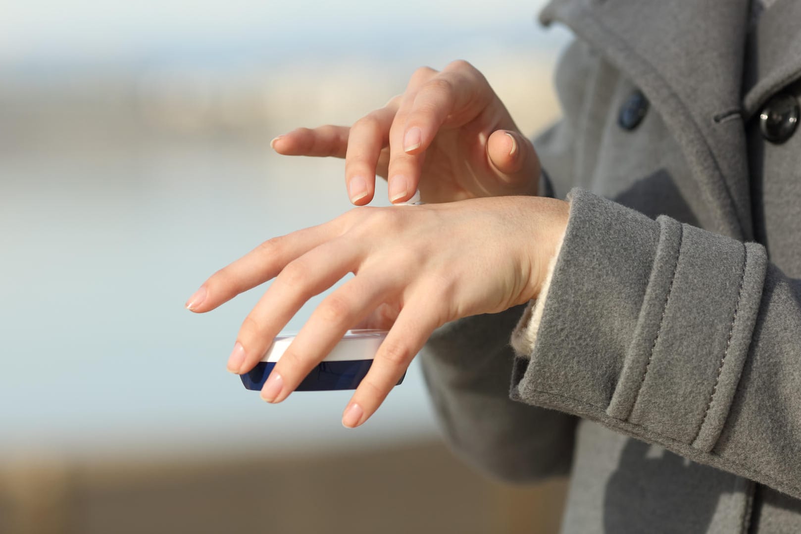 Frau macht im Winter Creme auf ihre Hand: Trockene Haut: Im Winter ist die Haut besonders anfällig.