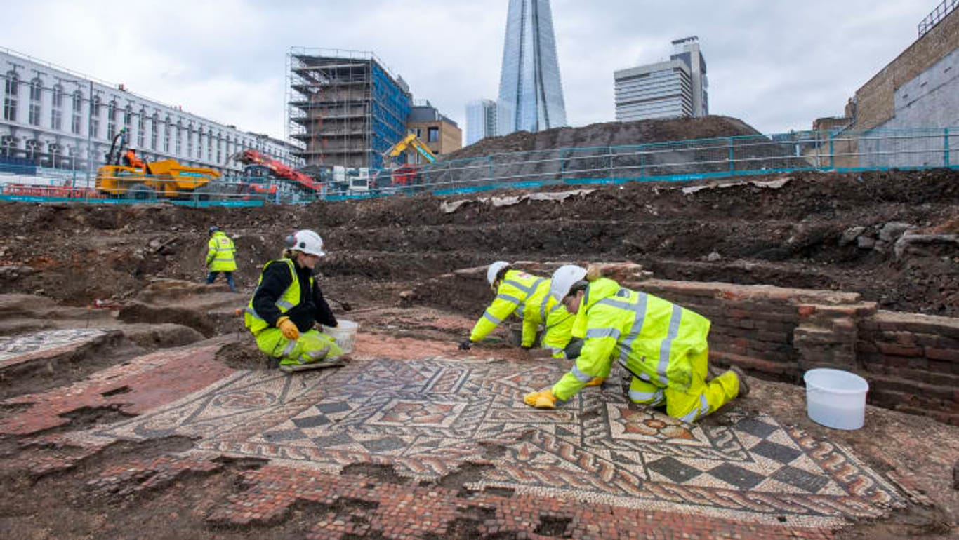 Mit feuchten Schwämmen werden die Mosaiksteine gesäubert: Immer wieder tauchen bei Bauarbeiten in London Artefakte aus der Zeit des römischen Kaiserreichs auf.