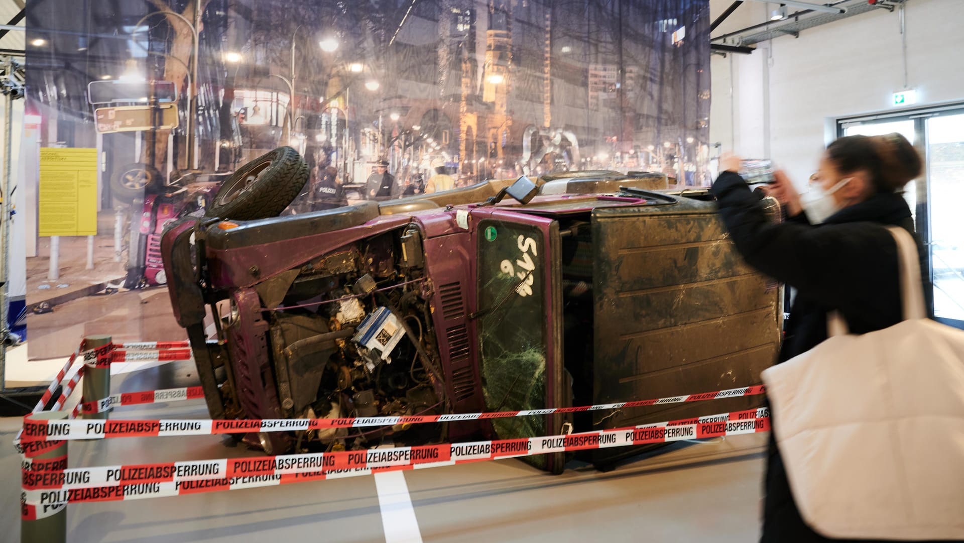 Eine Frau fotografiert mit ihrem Handy den zerstörten Jeep des Todesopfers des Kudamm-Rasers: Die Sonderausstellung ist vom 24. Februar bis zum 3. Juli 2022 im Deutschen Technikmuseum zu sehen. Eine Frau fotografiert mit ihrem Handy den zerstörten Jeep des Todesopfers des Kudamm-Rasers: Die Sonderausstellung ist vom 24. Februar bis zum 3. Juli 2022 im Deutschen Technikmuseum zu sehen.