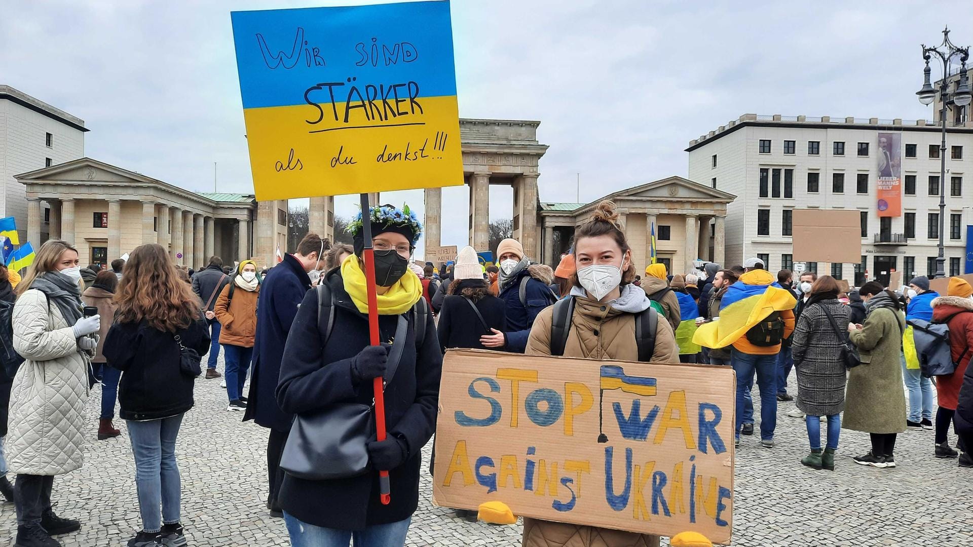 Zwei Frauen halten Schilder in die Luft.