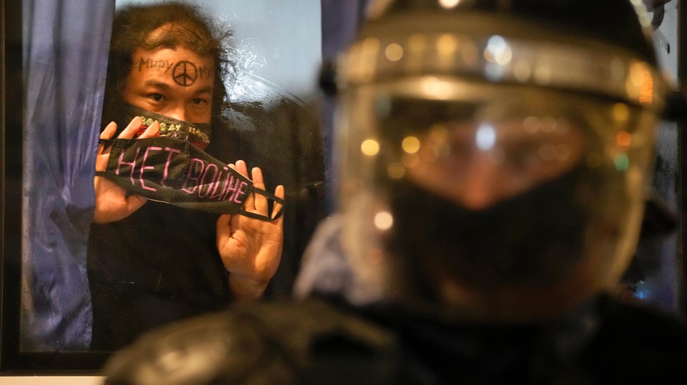 St. Petersburg: Ein festgenommener Demonstrant zeigt ein Schild mit der Aufschrift "Kein Krieg" aus einem Polizeibus.