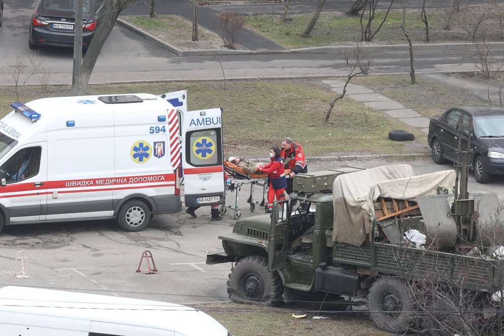 Rettungskräfte versorgen vor Kiew einen verwundeten russischen Soldaten: Auf beiden Seiten soll es bereits Hunderte Tote und Verletzte geben.