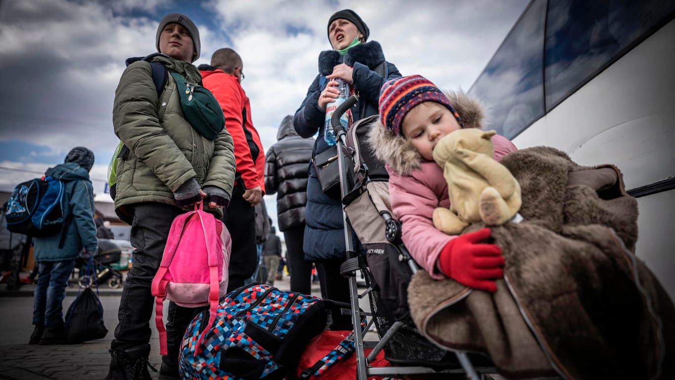 Ukrainer flüchten aus ihrer Heimat: Diese Familie wartet nach ihrem Grenzübertritt in Polen auf einen Bus, der sie zu einer Übergangsunterkunft bringt.