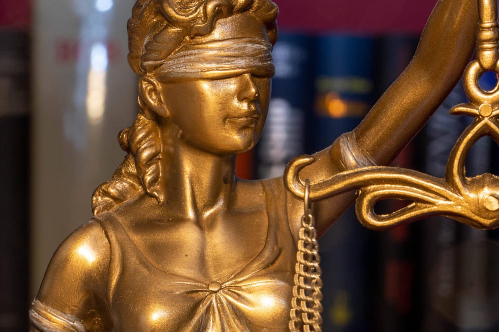 Ein Modell der Justitia vor Gesetzbüchern (Symbolbild): Das Gericht in Brescia verhandelt über den tödlichen Unfall.
