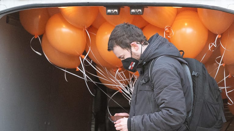 Ein Aktivist der "Letzten Generation" holt einen Strauß Heliumballons aus einem Transporter am Frankfurter Flughafen: In Berlin und München schafften es einige seiner Mitstreiter durch die Zäune in den Sicherheitsbereich. In Frankfurt stoppte die Polizei die Aktion bereits am Auto.