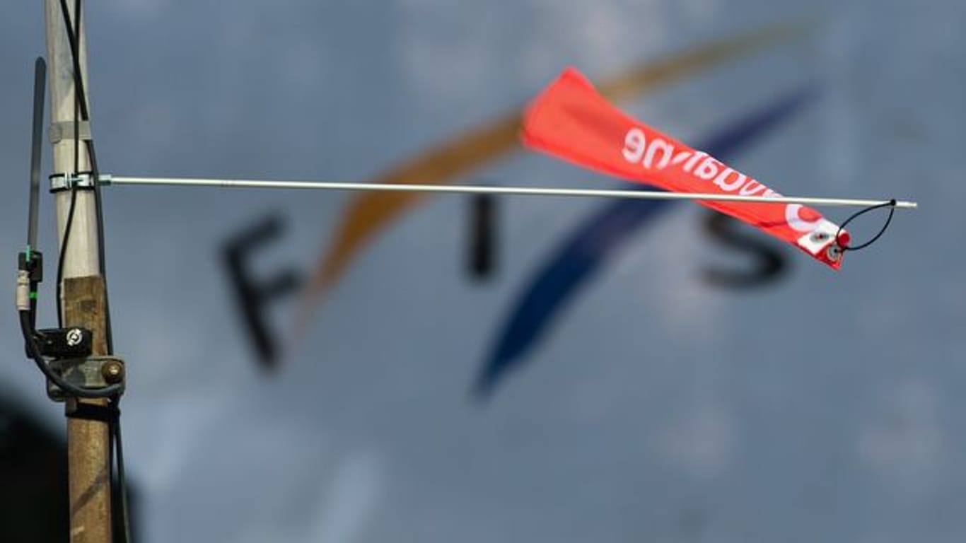 Ein Windfähnchen wehrt vor dem Logo der Fédération Internatonale de Ski (Fis).