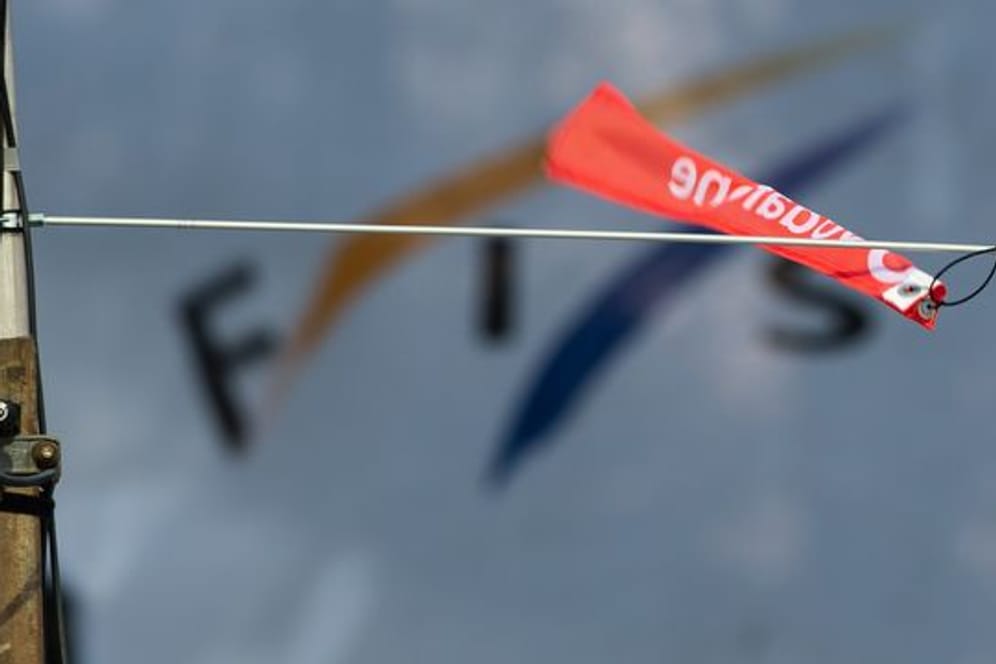 Ein Windfähnchen wehrt vor dem Logo der Fédération Internatonale de Ski (Fis).
