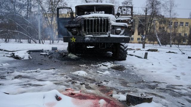 Blut ist im Schnee neben einem zerstörten russischen Militärfahrzeug am Stadtrand von Charkiw zu sehen.