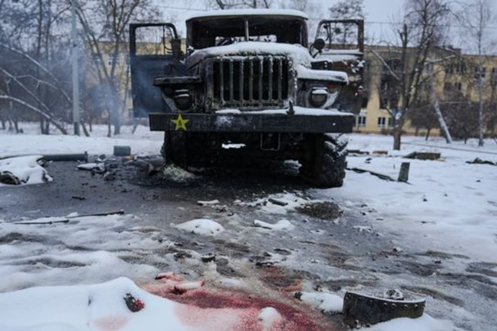 Blut ist im Schnee neben einem zerstörten russischen Militärfahrzeug am Stadtrand von Charkiw zu sehen.