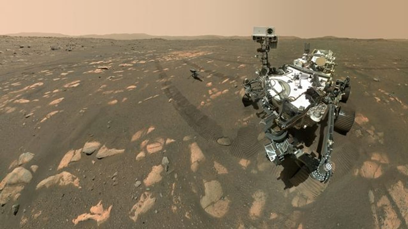 US-Rover "Perseverance" (r) neben dem Mini-Hubschrauber "Ingenuity" (M) auf dem Mars.