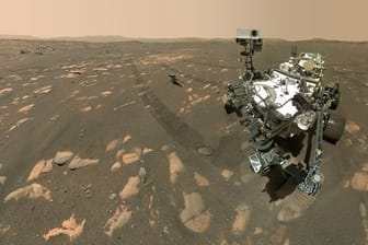 US-Rover "Perseverance" (r) neben dem Mini-Hubschrauber "Ingenuity" (M) auf dem Mars.
