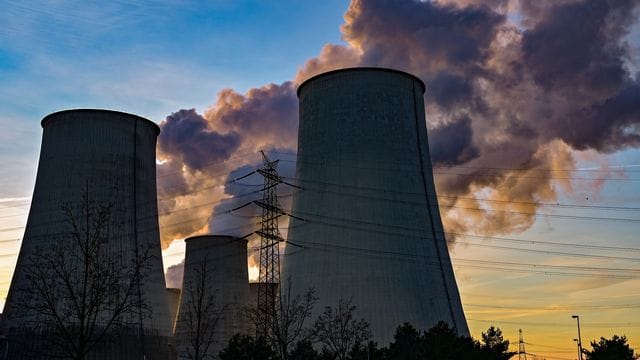 Wasserdampf steigt bei Sonnenuntergang aus den Kühltürmen eines Braunkohlekraftwerks. Wasserdampf steigt bei Sonnenuntergang aus den Kühltürmen eines Braunkohlekraftwerks.