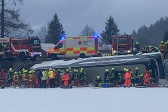 Helfer an der Unfallstelle: Der Bus stürzte am Samstagmorgen eine Böschung herunter.