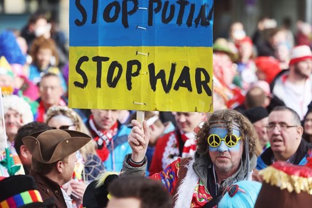 "Stop Putin": Ein Karnevalist verfolgt mit einem Transparent das traditionelle Funken-Biwak.