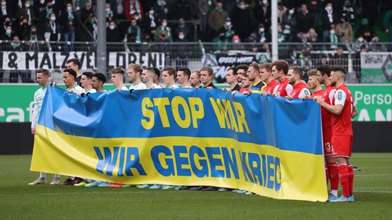 Fürther und Kölner Spieler halten zu Spielbeginn ein Transparent in den ukrainischen Farben mit der Aufschrift "Stop War.