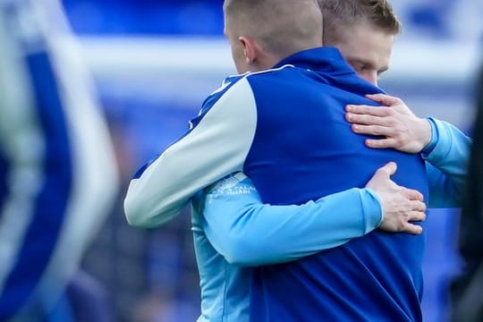 Die Ukrainer Alexander Zinchenko (l) von Manchester City und Vitali Mykolenko vom FC Everton umarmen sich vor dem Spiel.
