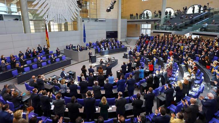 Ein voller Bundestag applaudiert dem Kanzler im Stehen.