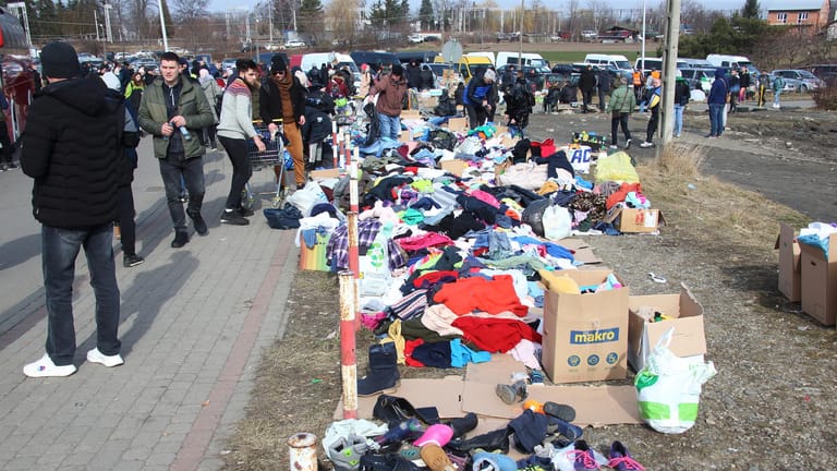 Freiwillige Helfer haben Kleidung und Schuhe hinter der Grenze ausgebreitet.