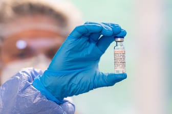 Eine Frau hält ein Fläschchen mit dem Impfstoff Nuvaxovid in der Hand (Symbolbild): Die Inzidenz in Deutschland sinkt wieder.