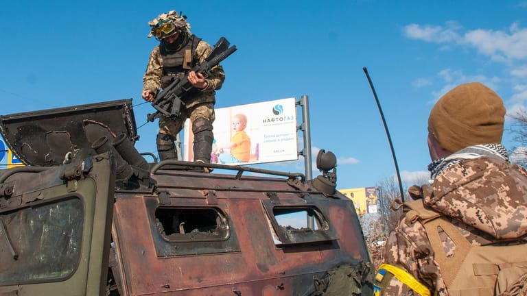Ukraine-Krieg: Ukrainische Soldaten inspizieren ein beschädigtes Militärfahrzeug nach Kämpfen in Charkiw.