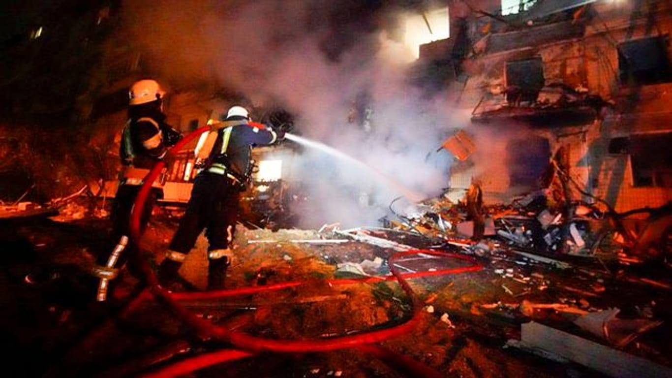 Feuerwehrleute löschen die Schäden an einem Gebäude nach einem Raketenangriff in Kiew.