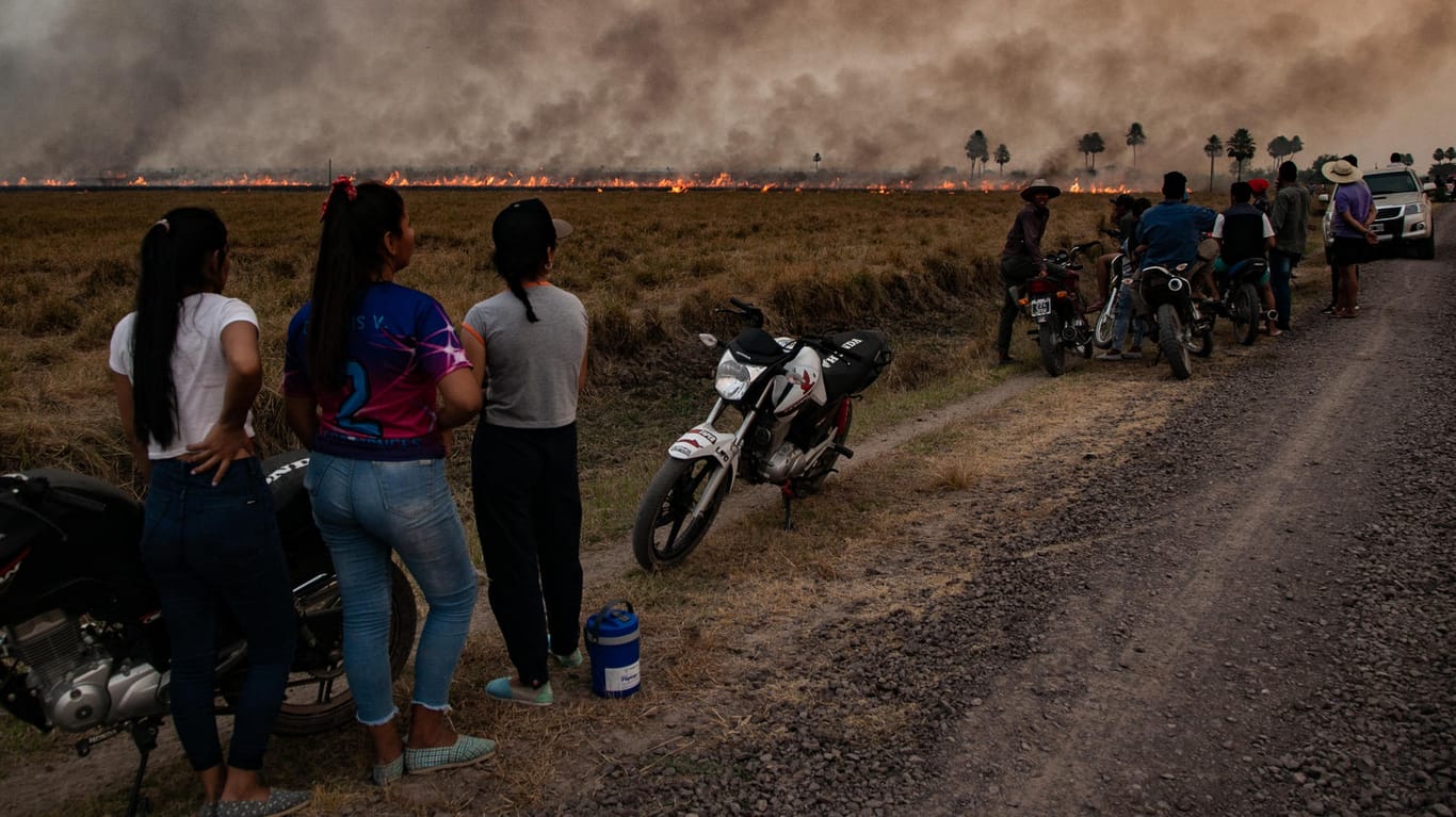 Anwohner beobachten Feuerwehrmänner und Freiwillige, die versuchen einen großen Waldbrand in Corrientes, Argentinien, zu löschen: Der Weltklimarat der UN beleuchtet in seinem neuesten Bericht die konkreten Gefahren der Klimakrise für Mensch und Natur.