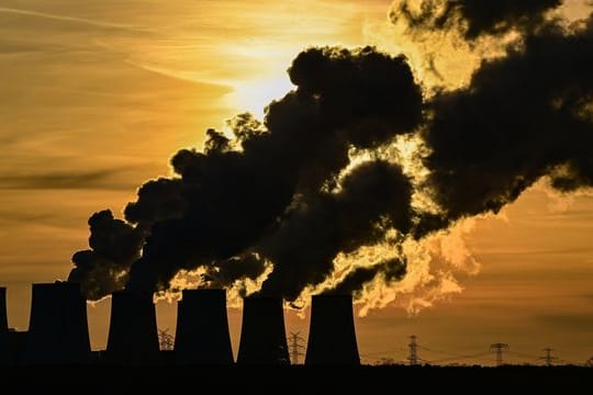 Wasserdampf steigt vor Sonnenuntergang aus den Kühltürmen des Braunkohlekraftwerks Jänschwalde der Lausitz Energie Bergbau AG (LEAG).