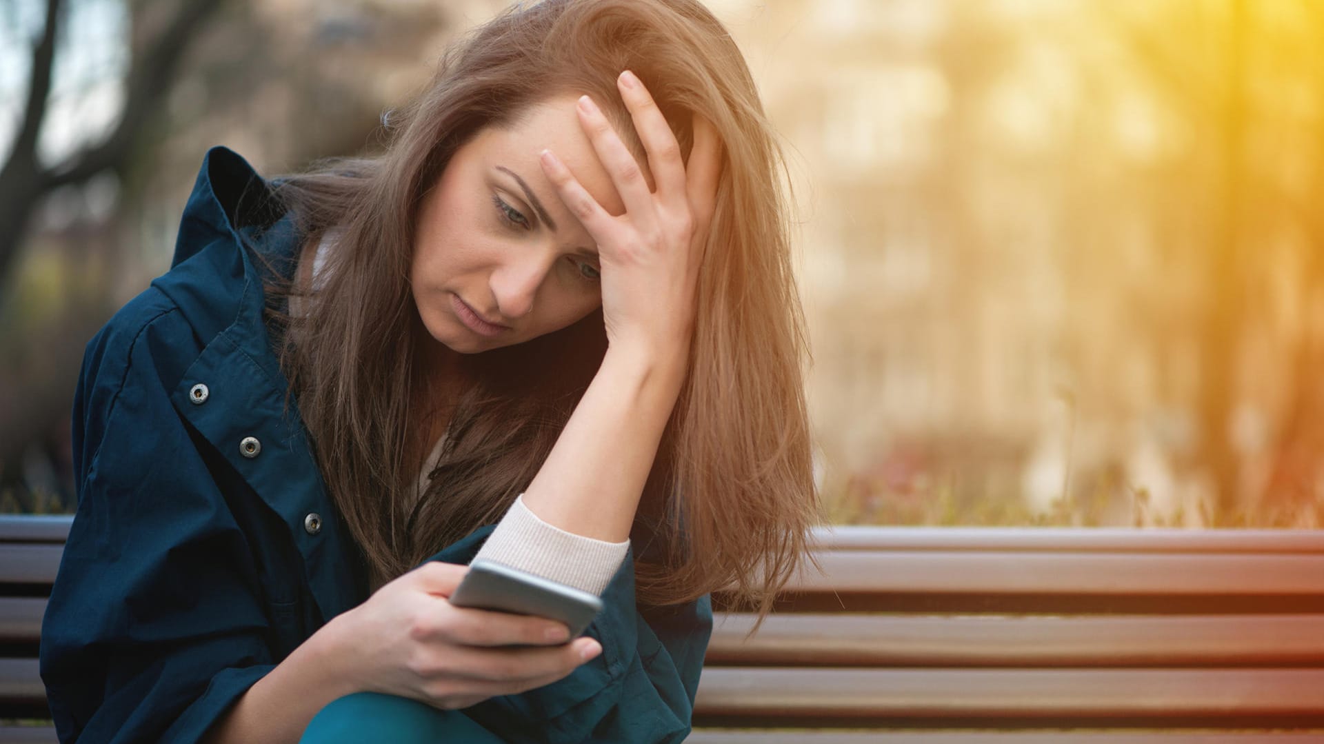 Eine junge Frau schaut auf ihr Smartphone.