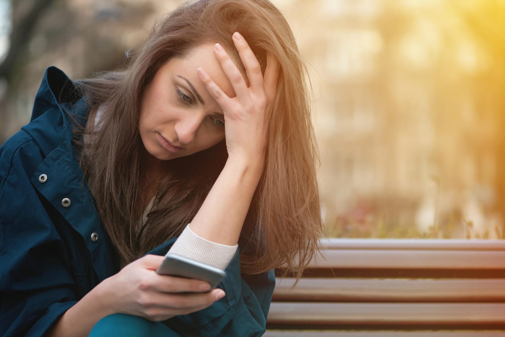 Eine junge Frau schaut auf ihr Smartphone.