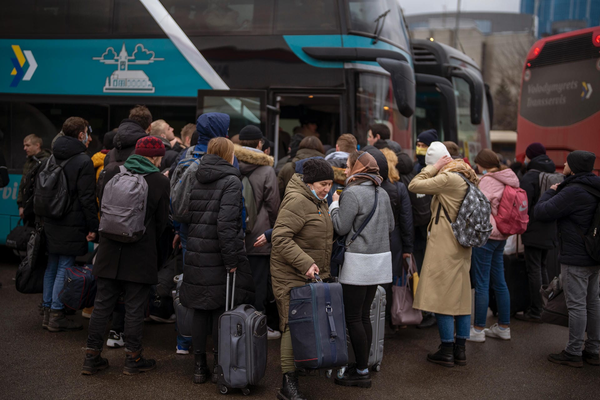Menschen drängen sich in Kiew in einen Bus. Mit Koffern und Rucksäcken versuchen sie, aus der Stadt zu fliehen.