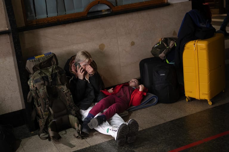 Eine Frau telefoniert, während sie mit ihrer Tochter auf einen Zug wartet: Zahlreiche Menschen fliehen aus der Ukraine.