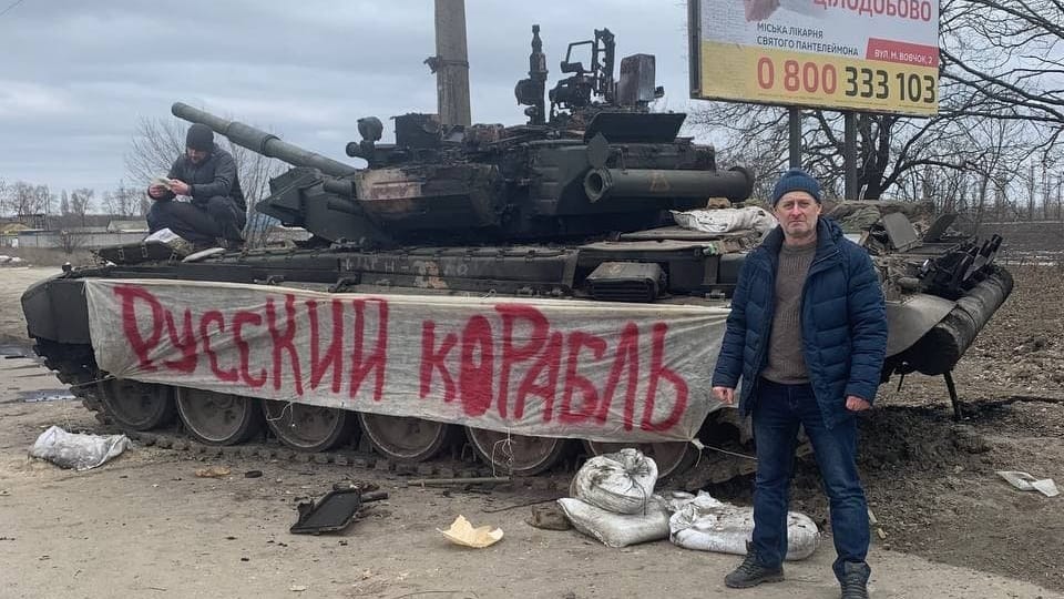 Ein Ukrainer in der Nähe von Sumy (Ostukraine) vor einem eroberten russischen Panzer