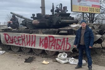 Ein Ukrainer in der Nähe von Sumy (Ostukraine) vor einem eroberten russischen Panzer