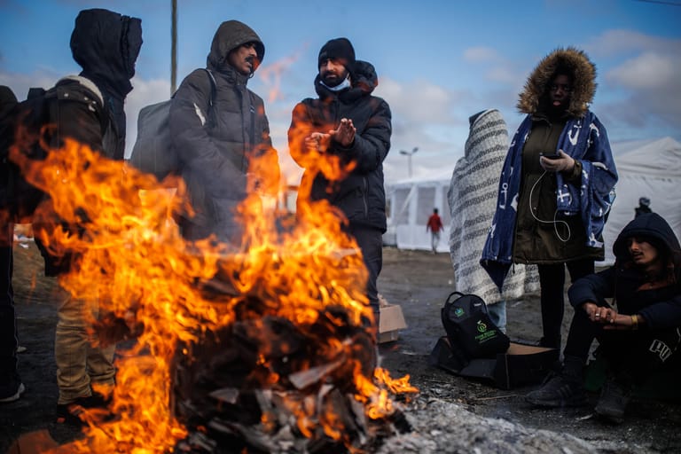 Medyka, Polen: Mehrere Menschen wärmen sich an einem Feuer am Grenzübergang auf. Wegen des Krieges sind nach Angaben des UN-Flüchtlingshilfswerks (UNHCR) Hunderttausende Menschen auf der Flucht.