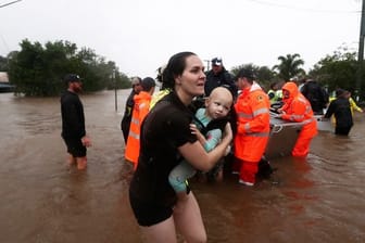 Eine Frau im australischen Lismore sucht mit Baby Schutz vor den Fluten.