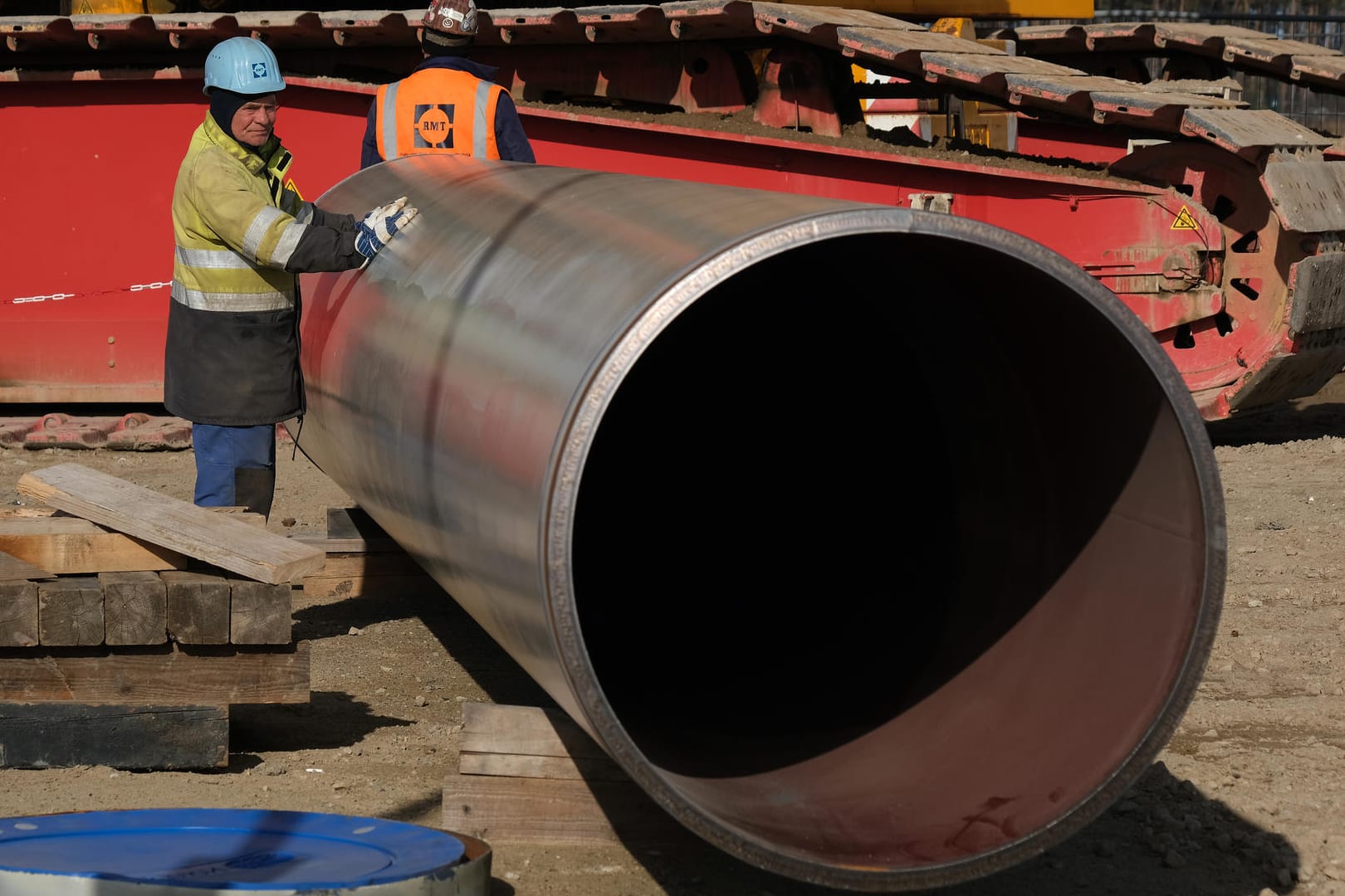 Ein Arbeiter steht neben einem Rohrabschnitt für Nord Stream 2: Der Betreiber der Pipeline kündigte nun allen Angestellten..