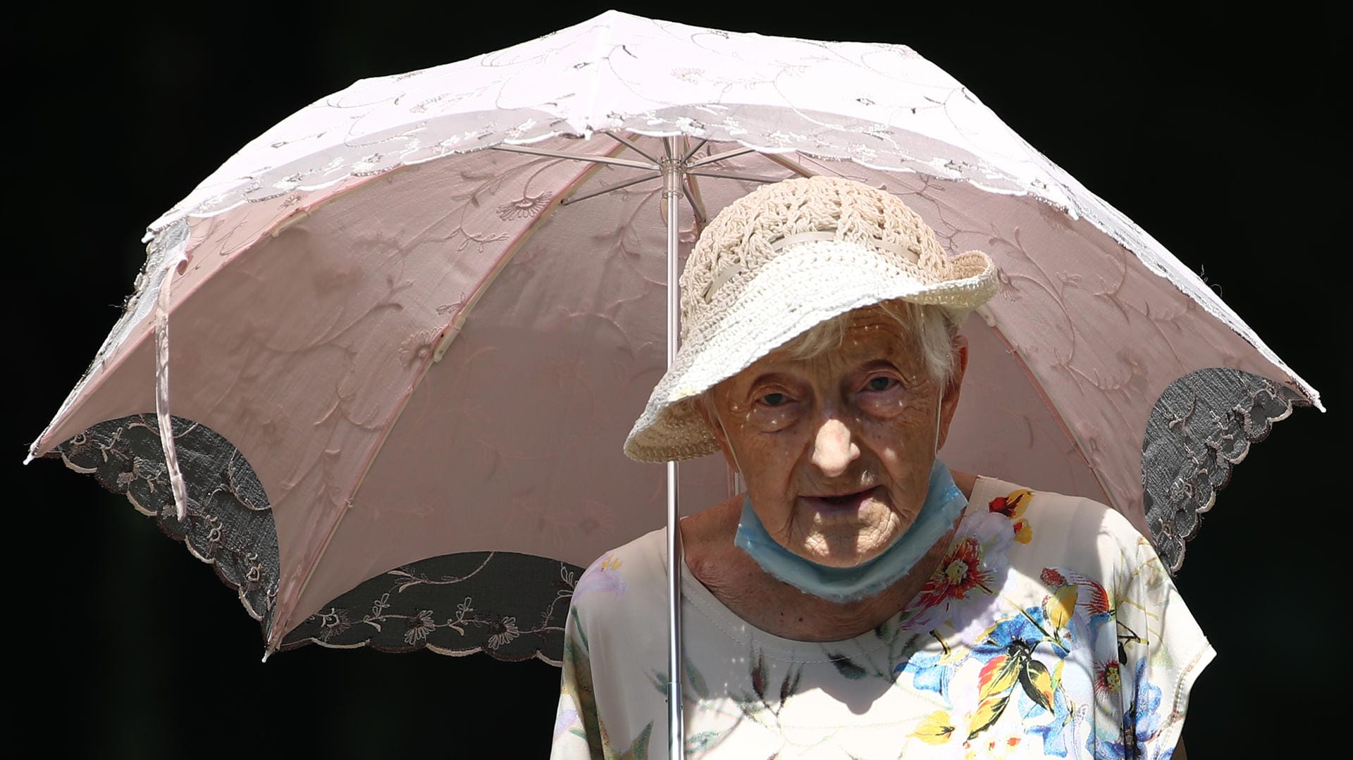 Eine alte Dame schützt sich vor der Sonne: Die Klimakrise ist vor allem ein gesundheitliches Risiko, sagt Eckart von Hirschhausen. Man müsse die Menschheit retten, nicht das Klima.