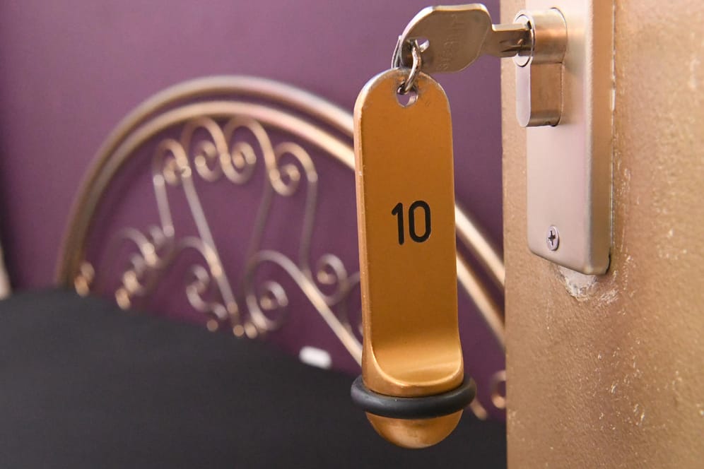 Ein Zimmerschlüssel hängt in einem Schloss an einer Zimmertür (Symbolbild): Illegale Prostitution hat in München seit der Corona-Pandemie zugenommen.
