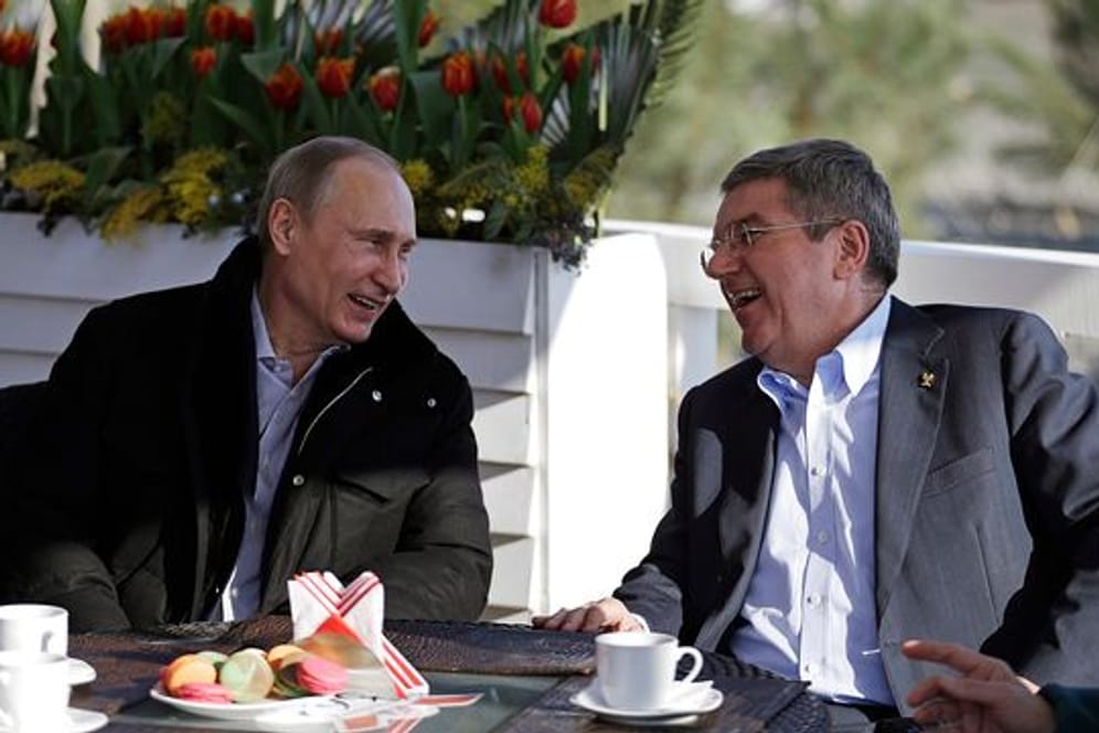 Der russische Präsident Wladimir Putin (l) und der IOC-Präsident Thomas Bach unterhalten sich in einem Cafe an der Promenade am schwarzen Meer während der Olympischen Spiele 2014 in Sotschi.