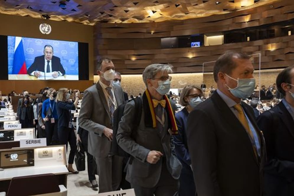 Botschafter und Diplomaten verlassen den Saal, während Sergej Lawrow (auf dem Bildschirm), Außenminister von Russland, mit einer aufgezeichneten Videobotschaft zur 49.