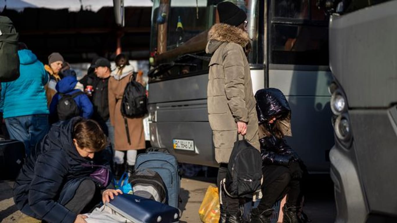 Ukrainische Bürger bereiten sich an einem Bahnhof im Westen der Ukraine vor, in einen Bus nach Polen einzusteigen.