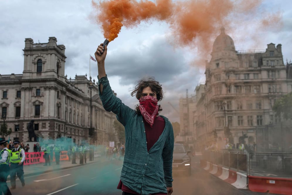 Ein Klimaaktivist der Gruppe Extinction Rebellion hält in London eine Rauchpatrone in die Luft: Die Symbolik der der Klimabewegung mag teils martialisch wirken. Doch beim Klimaschutz geht es tatsächlich um Leib und Leben, erklärt Eckart von Hirschhausen.