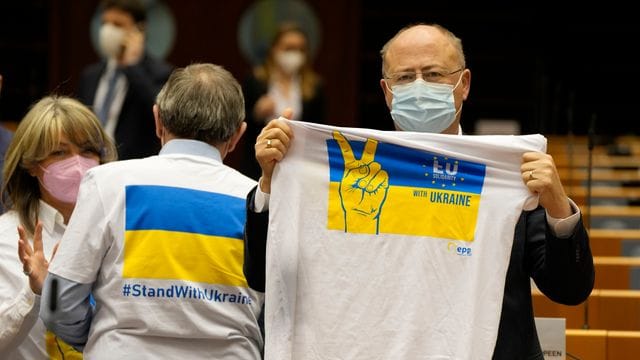 Ein Mitglied des Europäischen Parlaments hält ein T-Shirt in den Farben Blau und Gelb zur Unterstützung der Ukraine.