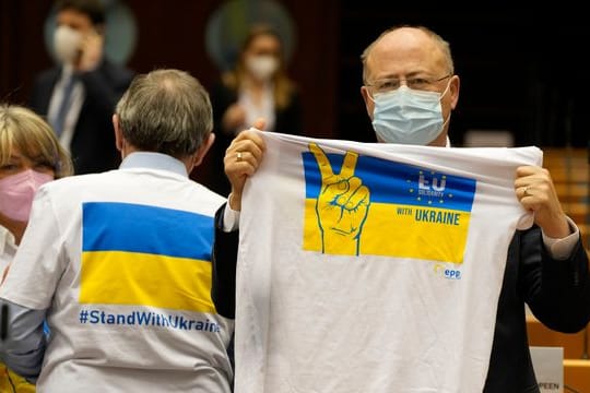 Ein Mitglied des Europäischen Parlaments hält ein T-Shirt in den Farben Blau und Gelb zur Unterstützung der Ukraine.