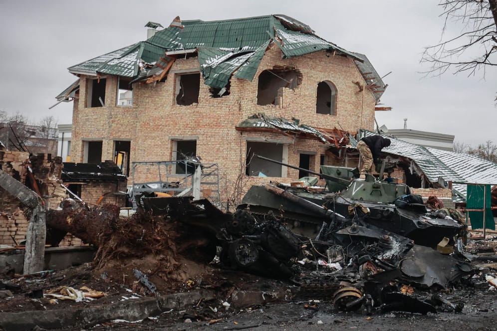 Butscha: Ein Mann betrachtet die ausgebrannten Überreste russischer Militärfahrzeuge.
