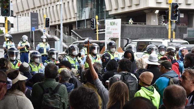 Demonstranten, die gegen das Impfmandat protestieren, stehen vor dem Parlamentsgebäude in Wellington. Demonstranten, die gegen das Impfmandat protestieren, stehen vor dem Parlamentsgebäude in Wellington.