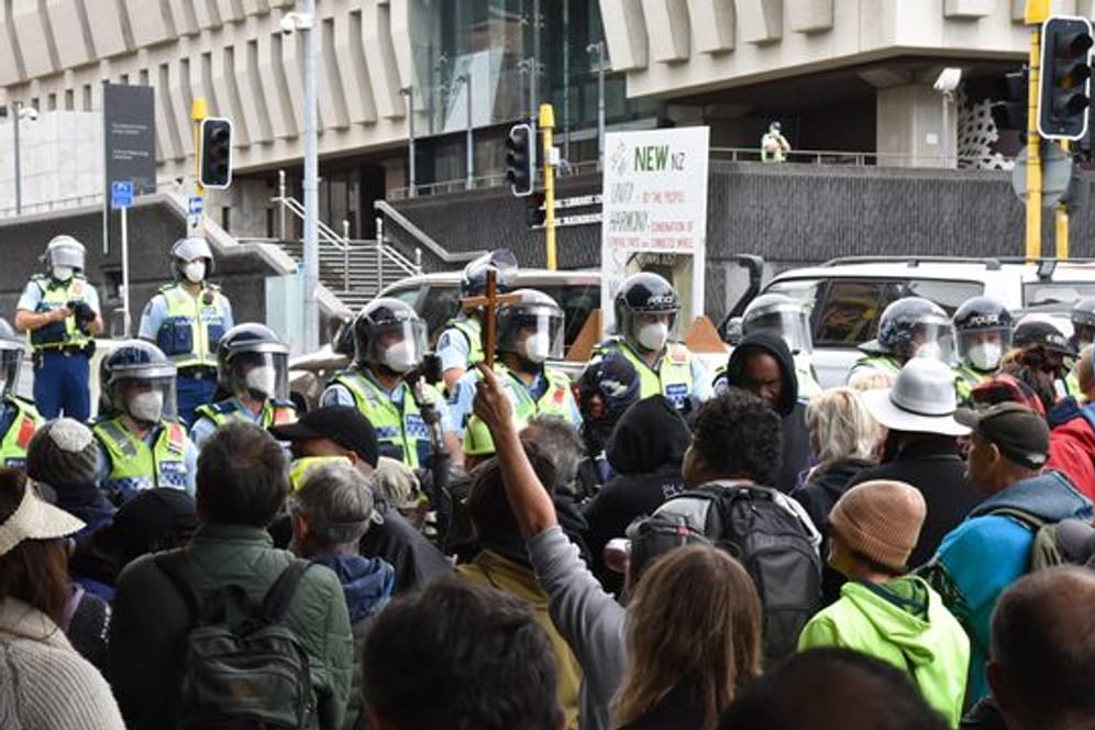 Demonstranten, die gegen das Impfmandat protestieren, stehen vor dem Parlamentsgebäude in Wellington.